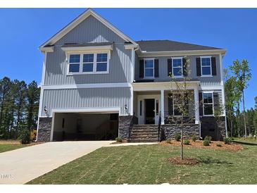 Beautiful home with gray siding, stone accents, and an attached two-car garage at 20 Bold Dr, Youngsville, NC 27596