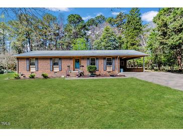 Charming single-story brick home with a well-maintained front yard and covered parking at 412 Winterlocken Dr, Sanford, NC 27330