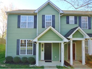 Charming two-story townhome featuring green siding, black shutters, and a welcoming covered front porch at 4425 Moss Garden Path, Raleigh, NC 27616