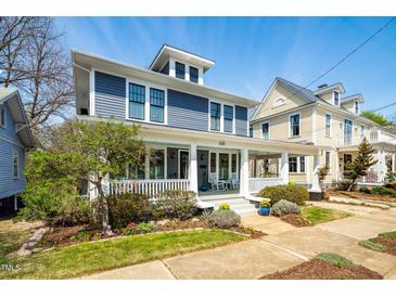 Charming blue two-story home boasts a welcoming front porch and manicured landscaping at 620 Wills Forest St, Raleigh, NC 27605