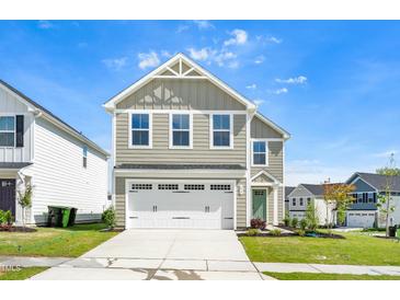 Charming two-story home with a two-car garage, sage green exterior, and manicured lawn at 653 Corvair Ln, Wendell, NC 27591