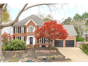 Beautiful brick two-story home with mature landscaping and a two-car garage at 109 S Fern Abbey Ln, Cary, NC 27518