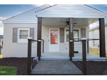 Charming single-story home featuring a covered porch with striking wooden pillars and a well-manicured front lawn at 1220 Garner Rd, Raleigh, NC 27610