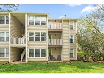 View of exterior of building with multiple balconies and grassy lawn at 1300 Hillbrow Ln # 204, Raleigh, NC 27615