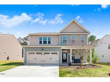 Charming two-story home with a front-entry garage and manicured lawn at 245 Naples Ln, Clayton, NC 27527