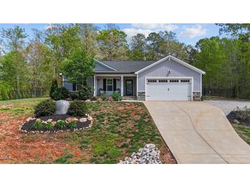 Charming single-story home with well-manicured lawn, landscaping, and attached two car garage at 25 S Treeline Dr, Spring Hope, NC 27882