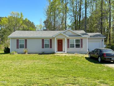 Charming single-story home featuring a red front door, well-manicured lawn, and attached garage at 35 Golden Poppy Ln, Youngsville, NC 27596