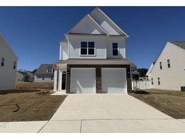 Beautiful two-story home with a two-car garage, brick accents, and a well-manicured lawn on a sunny day at 37 Furley St., Homesite 38, Sanford, NC 27330
