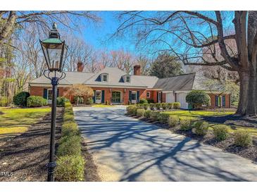 Elegant brick home with a well-maintained lawn and a long driveway lined with manicured shrubs at 382 Wimbledon Dr, Roxboro, NC 27573