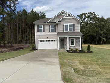 Charming two-story home featuring a two-car garage, stone accents, and a well-manicured lawn at 4012 Kingcraig Ln, Zebulon, NC 27597