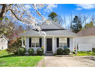 Charming single-story home with blossoming tree, well-kept lawn, and inviting entryway at 4118 Sudbury Rd, Durham, NC 27704