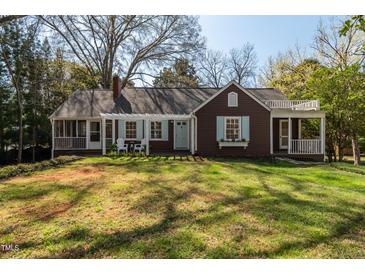 Charming home with a well-manicured lawn, inviting facade, and a cozy porch with outdoor seating at 55 Lindsey St, Pittsboro, NC 27312