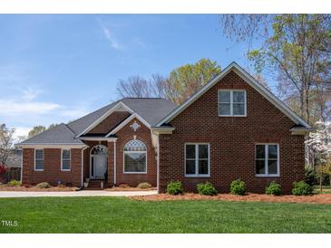 Charming brick home with well-manicured lawn, mature trees, and classic architectural details at 805 Lee St, Gibsonville, NC 27249