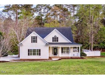 Charming white two-story home with a welcoming front porch and a well-manicured lawn at 924 Elbridge Dr, Raleigh, NC 27603