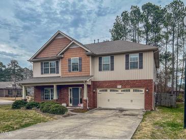Charming two-story home boasts brick and siding exterior, and a well-manicured front lawn at 1171 Jackson Ct, Creedmoor, NC 27522