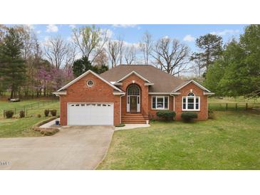 Lovely brick home with an attached garage and lush lawn at 2563 Millbrook Dr, Haw River, NC 27258