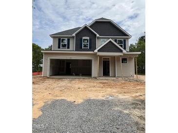 Two story home with large garage and craftsman design details under construction with dirt front yard at 268 Dove Rd, Cameron, NC 28326