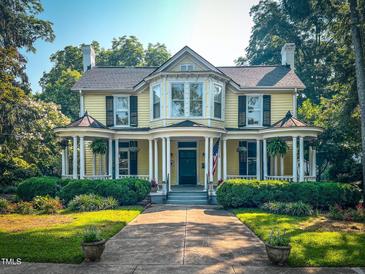 Charming yellow two-story home with manicured lawn and inviting front porch at 308 College St, Oxford, NC 27565