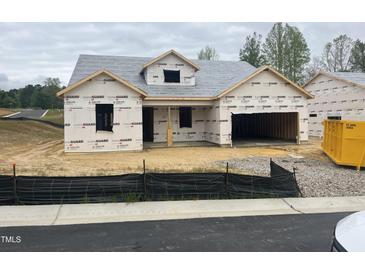 Unfinished home exterior shows construction with wrapped walls and framed windows, ready for customization at 312 Providence Creek Dr, Fuquay Varina, NC 27526