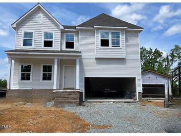 Charming two-story home with a welcoming front porch and an attached two car garage at 39 Atherton Circle, Angier, NC 27501