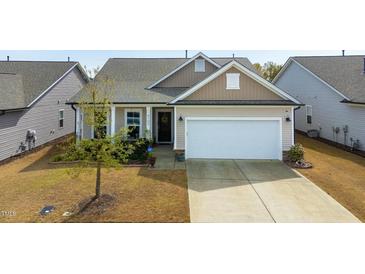 Inviting home featuring a two-car garage, neutral siding, manicured lawn and complementary landscaping at 4102 Catfish Way, Durham, NC 27703