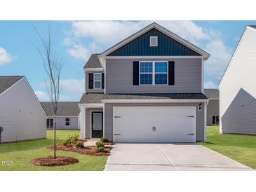 Charming two-story home with a two-car garage and well-manicured lawn at 54 Crow Field St, Roxboro, NC 27574