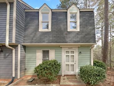 Charming home with a unique roofline, light green wood paneling and well manicured landscaping at 5620 Hamstead Xing, Raleigh, NC 27612