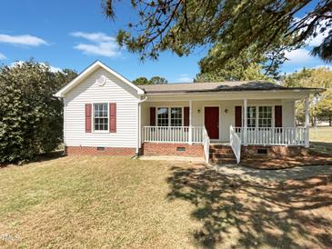 Charming single-story home with a cozy front porch and brick foundation details at 5908 O C Hester Rd, Holly Springs, NC 27540
