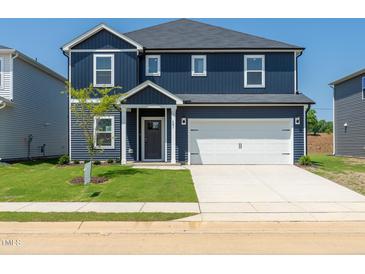 Two-story home with blue siding, white trim, a front-facing two-car garage, and a well-maintained front yard at 601 White Birch Ln, Angier, NC 27501