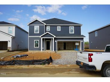 Two-story home showcasing its dark siding, white trim, and an attached two-car garage at 601 White Birch Ln, Angier, NC 27501