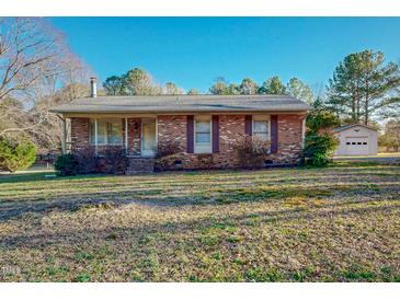 Charming brick ranch-style home with a well-maintained lawn and detached garage at 604 Orange Factory Road, Bahama, NC 27503