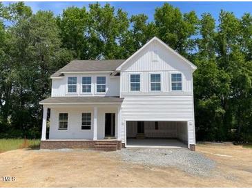 New two-story home showcasing white siding, multiple windows, and an attached two-car garage at 61 Atherton Circle, Angier, NC 27501