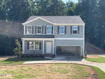 Charming two-story home with a covered front porch, attached two-car garage, and well-maintained lawn at 62 Atherton Circle, Angier, NC 27501