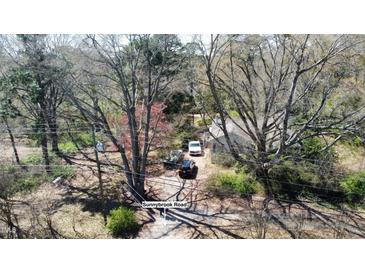 Aerial view of a charming home with mature trees and a driveway leading to Sunnybrook Road at 620 Sunnybrook Rd, Raleigh, NC 27610