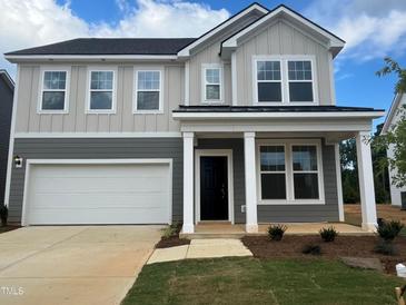 Charming two-story home featuring a two-car garage and well-manicured lawn at 766 Old Station Pointe, Angier, NC 27501