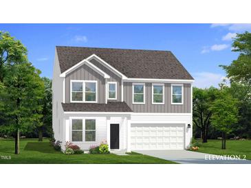 Charming two-story home with a mix of vertical and horizontal siding, complemented by lush landscaping at 766 Old Station Pointe, Angier, NC 27501