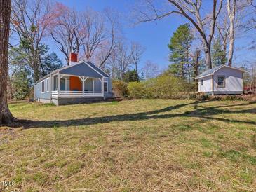 Charming cottage-style home with blue siding, white trim, covered porch and spacious yard at 774 Cornelius St, Hillsborough, NC 27278