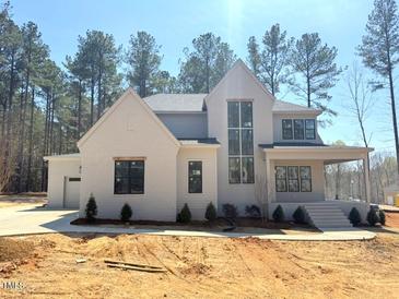 Stunning two-story home with a modern white brick exterior, covered porch, and large windows at 7808 Ailesbury Rd, Wake Forest, NC 27587
