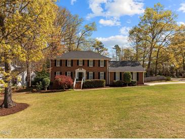 Beautiful two-story brick home with a large front lawn and mature trees, offering classic charm at 8000 N Bridgewater Ct, Raleigh, NC 27615