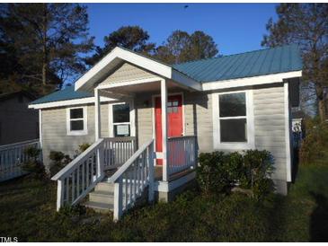 Charming one-story home with a blue metal roof, covered porch, and inviting red door at 912 Martin Luther King Jr Dr, Smithfield, NC 27577