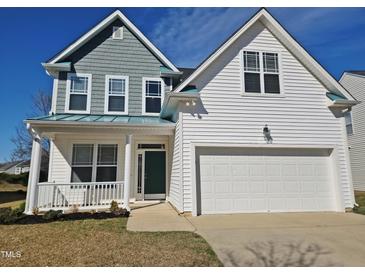 Charming two-story home featuring a two-car garage, inviting porch, and stylish design elements at 1036 Steelhorse Dr, Fuquay Varina, NC 27526