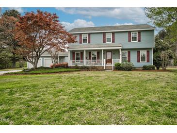 Inviting two-story home features a charming front porch, red shutters, and a spacious lawn perfect for outdoor enjoyment at 108 Birdie Ct, Rocky Mount, NC 27804