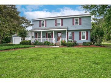Charming blue two-story home featuring a welcoming front porch, red shutters and well-manicured lawn at 108 Birdie Ct, Rocky Mount, NC 27804