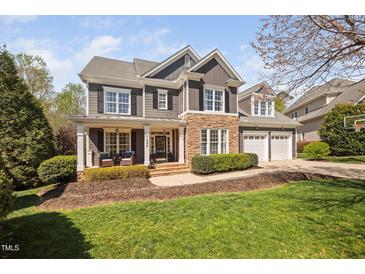 Charming two-story home featuring a stone and siding facade, well-manicured lawn and a two car garage at 1204 Croydon Glen Ct, Cary, NC 27519