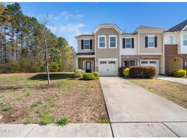 Inviting two-story home with a lush front yard and a double-car garage at 1220 Falcon Ridge Ln, Morrisville, NC 27560
