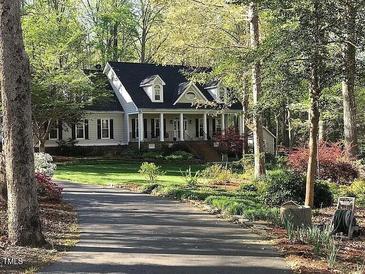 Charming home with a welcoming front porch, manicured lawn, and mature trees at 1229 Westerham Dr, Wake Forest, NC 27587