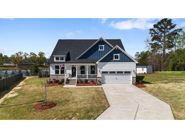 Charming two-story home features a manicured lawn, attached two-car garage, and inviting front porch at 16 Blue Monarch Ln, Fuquay Varina, NC 27526