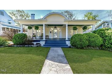 Charming home featuring a lovely front porch, lush landscaping, and inviting curb appeal at 211 W Chisholm St, Sanford, NC 27330