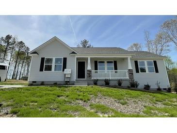 Charming single-story home featuring a covered front porch and professionally landscaped yard at 279 Constellation Ct, Benson, NC 27504