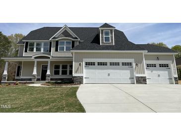 Charming two-story home with a two-car garage and stone accents, enhancing curb appeal at 308 Busterfield Ct, Benson, NC 27504